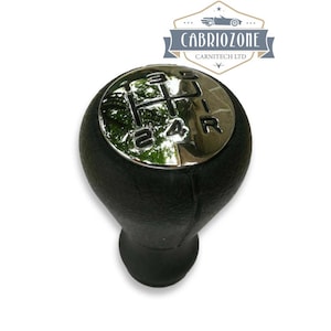 May include: Black leather gear shift knob with a chrome top. The top has the numbers 1, 2, 3, 4, 5, and R engraved on it.
