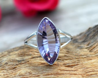 May include: A silver ring with a marquise-shaped amethyst gemstone. The gemstone is a light purple color and has a faceted cut.