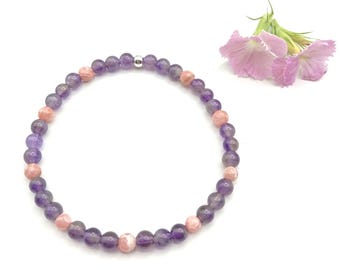 May include: A delicate bracelet made with amethyst and pink gemstone beads. The bracelet is strung on a silver wire and has a simple design.