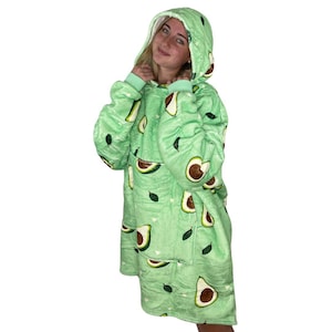 Könnte beinhalten: Eine grüne Kapuzendecke mit Avocado-Druck. Die Decke hat eine große Kapuze und lange Ärmel.