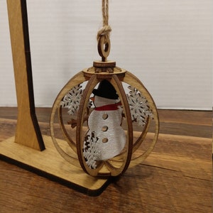 Snowman globe ornament laser cut wood.