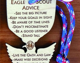 May include: Wooden Eagle Scout advice keychain with a blue and red lanyard. The keychain features the Eagle Scout logo and text that reads "Eagle Scout Advice" and includes tips for success.