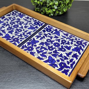 May include: A wooden serving tray with two removable ceramic tiles. The tiles feature a blue and white floral pattern.