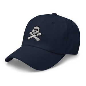 May include: A navy blue baseball cap with a white embroidered skull and crossbones design.