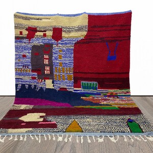May include: A colorful abstract rug with geometric patterns in shades of red, blue, green, yellow, and white. The rug has a fringe border.