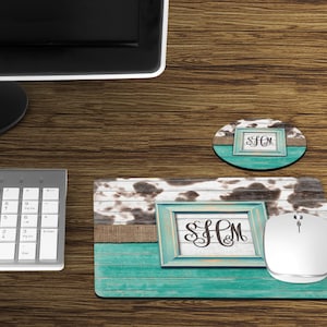 May include: A turquoise and brown cowhide patterned mousepad with a framed monogram "SHM" in the center. The mousepad is on a wooden surface with a matching turquoise and brown cowhide patterned coaster with the monogram "SHM" in the center.