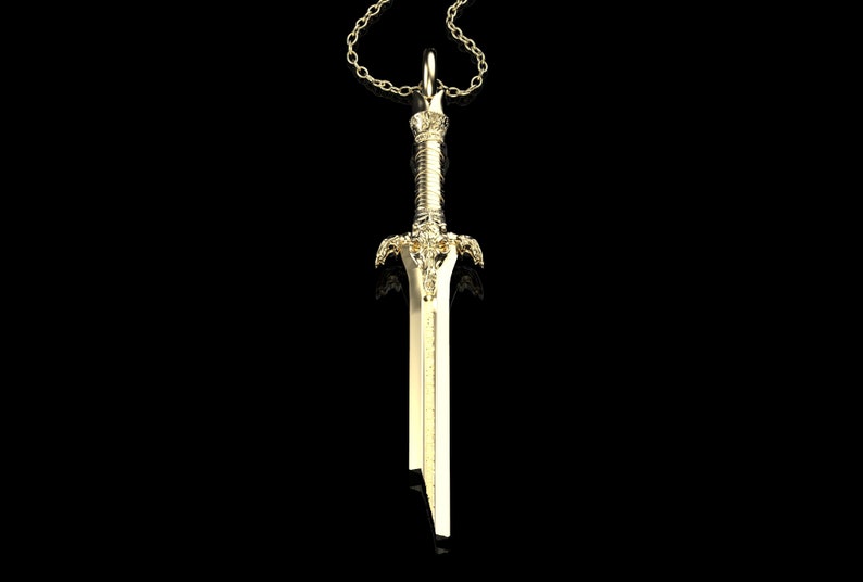May include: A gold-coloured sword pendant necklace. The sword has a detailed design with a pointed tip and a decorative handle.
