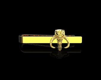 May include: Gold tie clip with a Mandalorian helmet design.