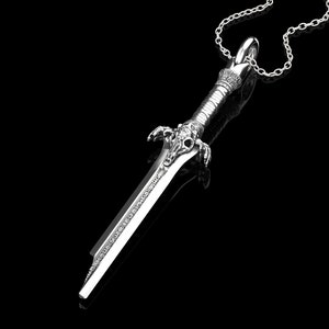 K&ouml;nnte beinhalten: Eine silberne Schwertpendantkette mit einem detaillierten Design. Das Schwert hat eine spitze Spitze und einen dekorativen Griff. Die Kette ist an einer silbernen Kette.