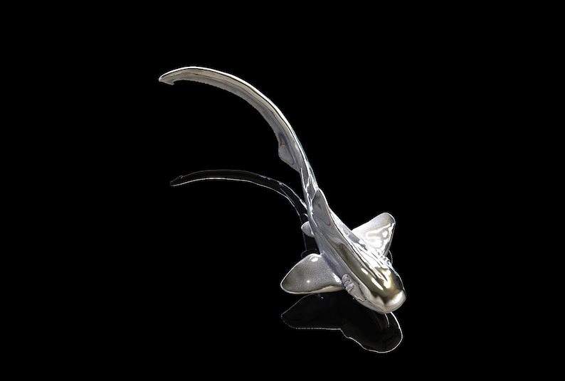May include: A silver-colored shark sculpture with a long, curved tail. The sculpture is posed as if it is swimming, with its head tilted upwards. The sculpture is set against a black background.