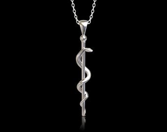 Op de afbeelding: Een zilveren ketting met een hanger met de Caduceus, een symbool van de geneeskunde, met een slang om een staf gewikkeld.