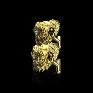 May include: A pair of gold lion head cufflinks. The cufflinks are detailed and have a realistic look.