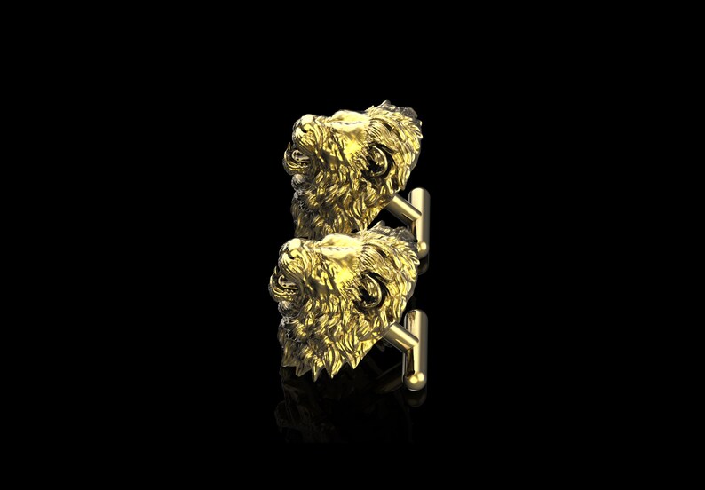 May include: A pair of gold lion head cufflinks. The cufflinks are detailed and have a realistic look.