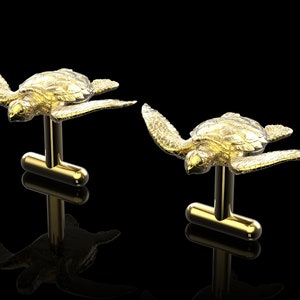May include: A pair of gold cufflinks featuring a detailed, three-dimensional sea turtle design.