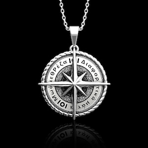 Peut inclure: Collier avec pendentif en forme de boussole en argent avec un motif d'étoile et des lettres grecques sur le bord. Les lettres indiquent "Διάσωρ τικς ίωτ ίωμ εζορ έζα".