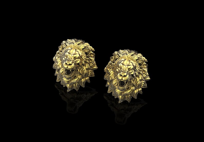 May include: A pair of gold lion head cufflinks. The lion heads are detailed and have a roaring expression.