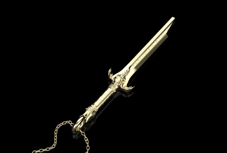 May include: A gold-coloured sword pendant necklace with a detailed design. The sword has a pointed tip and a decorative handle. The necklace is made of a gold chain.