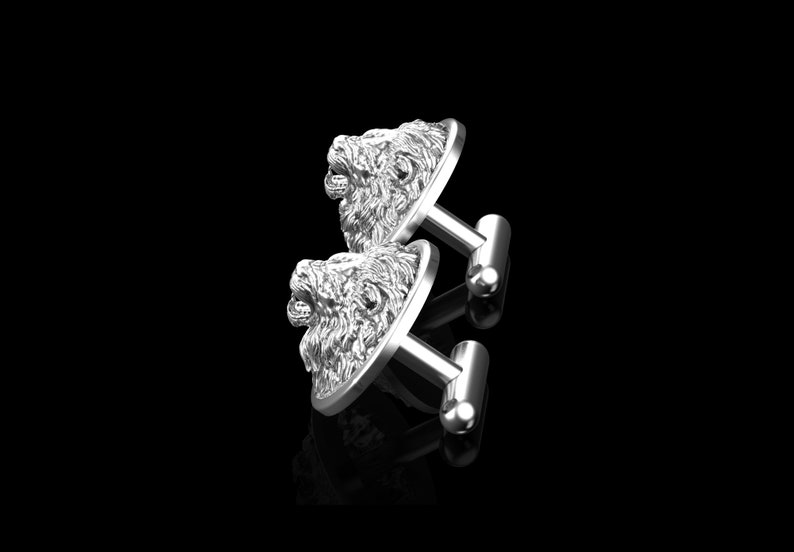 May include: A pair of silver cufflinks featuring a detailed lion head design. The cufflinks are made of polished metal and have a classic, elegant look.