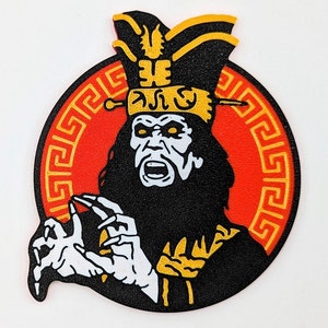 Puede incluir: Una ilustración en blanco y negro de una persona que lleva un sombrero amarillo y negro con un borde de estilo chino rojo y amarillo alrededor de la imagen. La persona está haciendo un gesto con la mano.