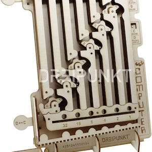 Puede incluir: Un ordenador de juguete de madera con un sistema de números binarios. El juguete tiene una serie de pistas con bolas que se pueden mover para representar diferentes números. El juguete está hecho de madera y tiene un acabado natural. El juguete está etiquetado como "COMPUTER" y "DREIPUNKT".