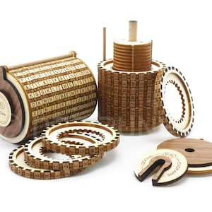 Può includere: Una macchina cifrante in legno con più dischi rotanti, ognuno con le lettere dell'alfabeto. La macchina è realizzata in legno marrone chiaro e ha un meccanismo di bloccaggio in metallo. La macchina è in stile vintage ed è un ottimo modo per aggiungere un tocco di storia alla tua casa.