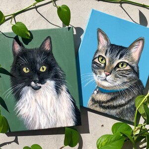 K&ouml;nnte beinhalten: Zwei Katzengem&auml;lde auf Leinw&auml;nden. Die Katze links ist schwarz-wei&szlig; mit einer wei&szlig;en Brust und einem gr&uuml;nen Hintergrund. Die Katze rechts ist getigert mit einem blauen Hintergrund.