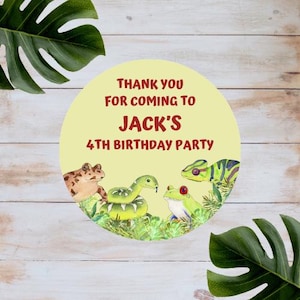 May include: A circular sticker with a pale yellow background featuring the text THANK YOU FOR COMING TO JACK'S 4TH BIRTHDAY PARTY in dark red. Below the text are illustrations of a brown toad, a green snake, and a green frog with red eyes.