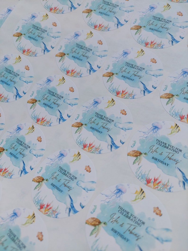 May include: Round stickers with a watercolor design of a turtle, jellyfish, and fish. The stickers say "Thank you for celebrating Isla & Tobias' Birthday."