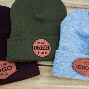 May include: Four different colored knit beanies with leather patches that say "your logo here".