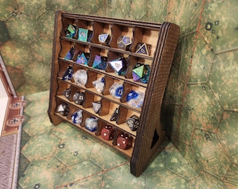 May include: A wooden dice display rack with multiple compartments, filled with various polyhedral dice in different colors and materials. The rack is made of dark wood and has a slanted design.