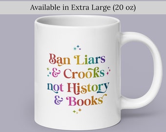 May include: White ceramic mug with a rainbow coloured design that says "Ban Liars & Crooks not History & Books".