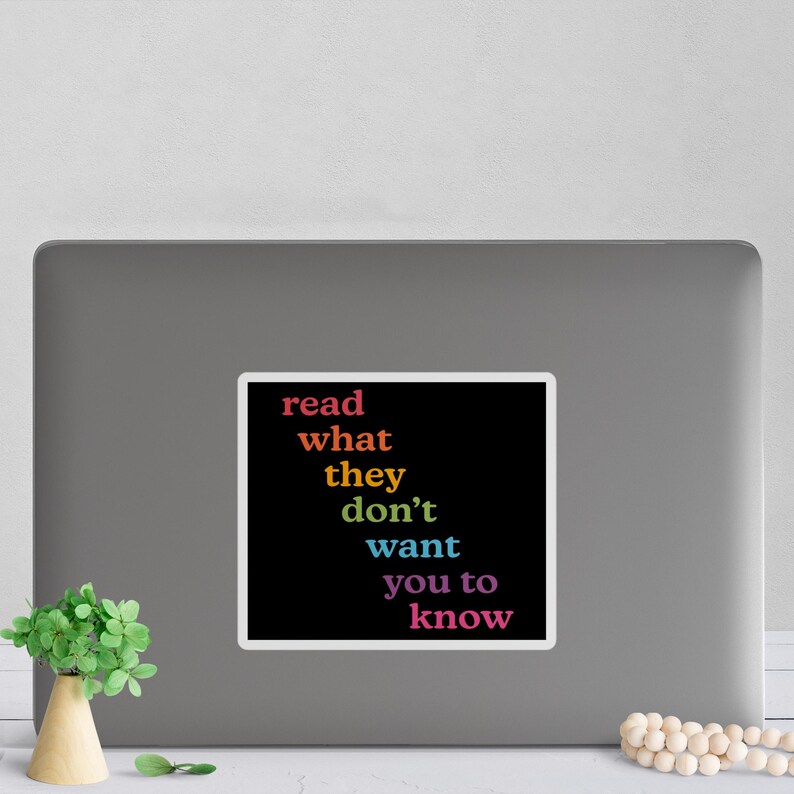 May include: A black and white sticker with the text "read what they don't want you to know" in rainbow colors.