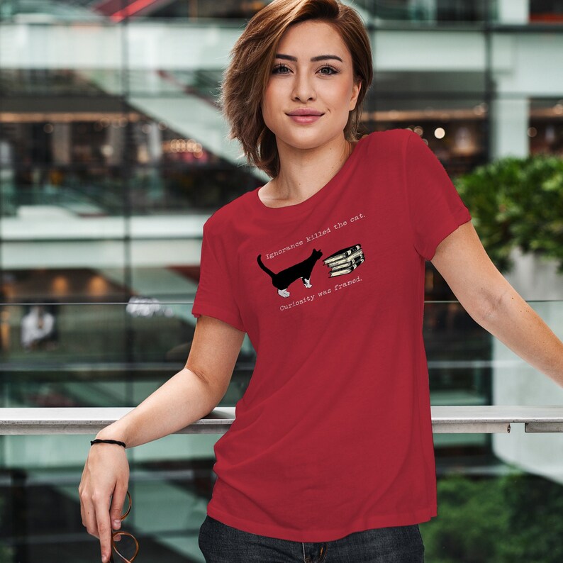 May include: Red t-shirt with a black and white cat illustration and the text "Ignorance killed the cat. Curiosity was framed."