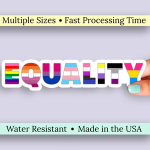 May include: A sticker with the word "EQUALITY" in colorful letters, each representing a different LGBTQ+ identity. The sticker is held by a hand with a painted teal fingernail. The sticker is water resistant and made in the USA.