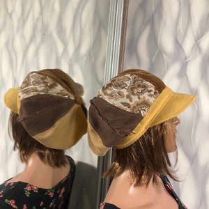 May include: A patchwork newsboy cap with a brown corduroy top, floral patterned fabric, and tan and brown panels. The brim is a solid tan colour. The cap is displayed on a mannequin.