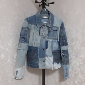 May include: A blue denim jacket made from patchwork denim with multiple pockets and a button closure.