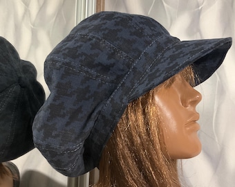 May include: A navy blue and black patterned hat with a short brim. The hat has a rounded crown and is made of a fabric with a pixelated design. The hat is a stylish accessory.