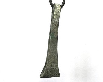 May include: A dark gray metal pendant shaped like a long, narrow blade with a rounded tip. The pendant is hanging from a black cord.