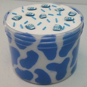 May include: A white and blue cow print slime container with blue sprinkles and miniature milk carton charms.