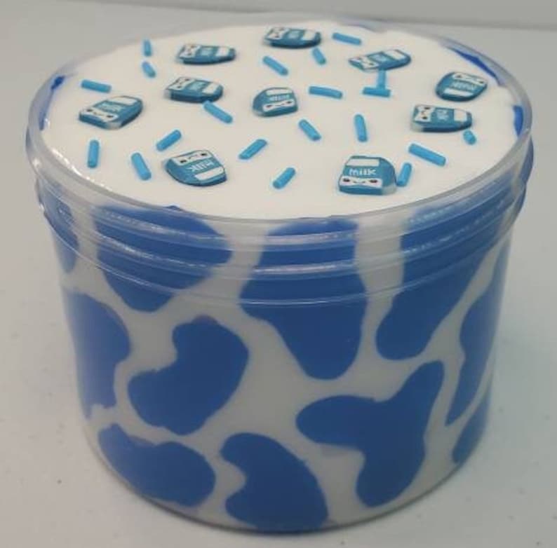 May include: A white and blue cow print slime container with blue sprinkles and miniature milk carton charms.