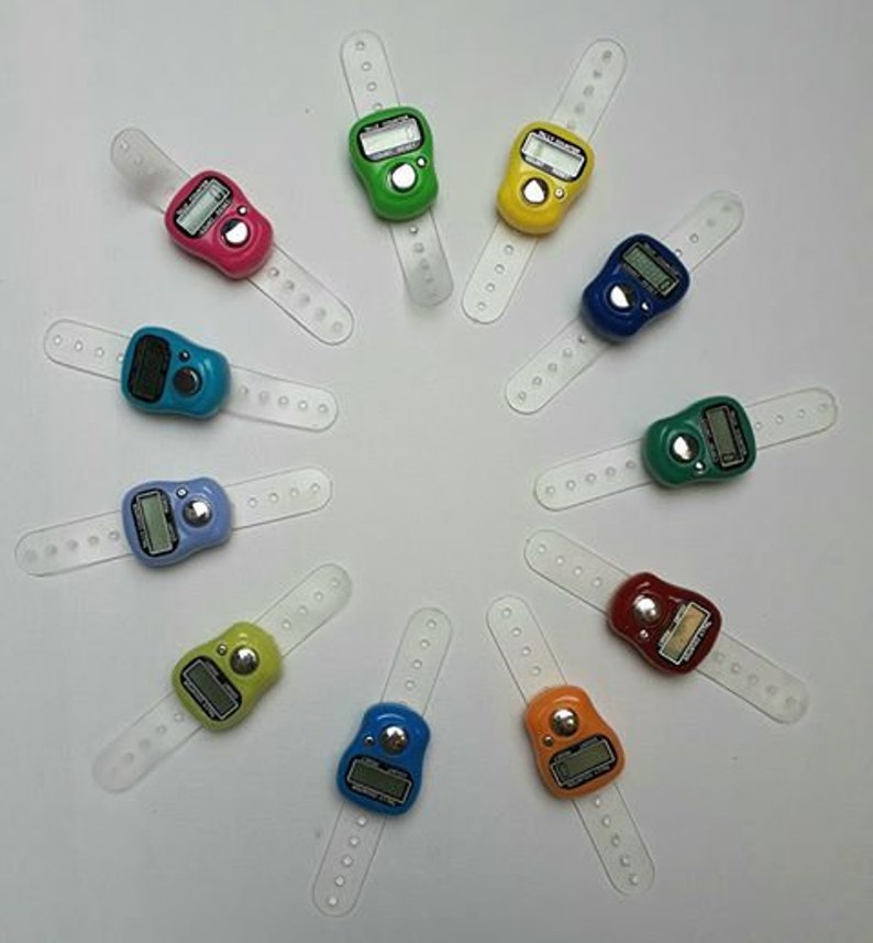 May include: Ten digital prayer counters with clear plastic straps. The counters are in various colors, including blue, green, yellow, red, and black. Each counter has a small digital display.