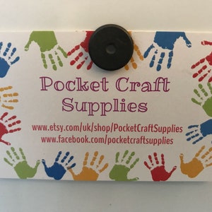 May include: A white business card with a colorful handprint border. The text "Pocket Craft Supplies" is in purple lettering. The website addresses "www.etsy.com/uk/shop/PocketCraftSupplies" and "www.facebook.com/pocketcraftsupplies" are printed below the business name.