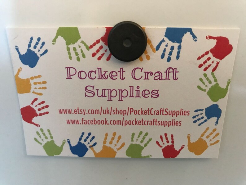 May include: A white business card with a colorful handprint border. The text "Pocket Craft Supplies" is in purple lettering. The website addresses "www.etsy.com/uk/shop/PocketCraftSupplies" and "www.facebook.com/pocketcraftsupplies" are printed below the business name.