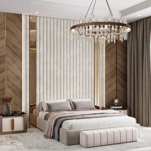 Op de afbeelding: Een slaapkamer met een groot bed met een witte hoofdeinde en een wit dekbed. Het bed heeft een roze voeteneinde en een roze voetenbank. Een grote kristallen kroonluchter hangt aan het plafond. De muren zijn lichtbruin en de vloer is van hout.