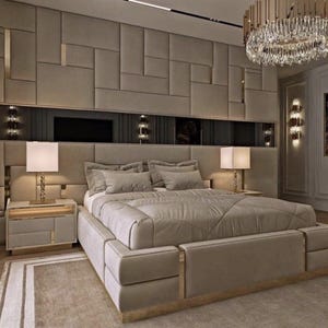 Peut inclure: Chambre luxueuse avec un grand lit dot&eacute; d'une t&ecirc;te de lit beige rembourr&eacute;e et d'une literie assortie. Deux tables de chevet avec lampes encadrent le lit. La pi&egrave;ce pr&eacute;sente un design mural g&eacute;om&eacute;trique, un lustre et une palette de couleurs neutres.
