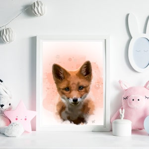 Puede incluir: Una impresi&oacute;n art&iacute;stica enmarcada con una pintura de acuarela de un cachorro de zorro. El zorro tiene pelaje marr&oacute;n rojizo y est&aacute; sobre un fondo melocot&oacute;n suave con salpicaduras de pintura. La obra est&aacute; en un marco blanco.