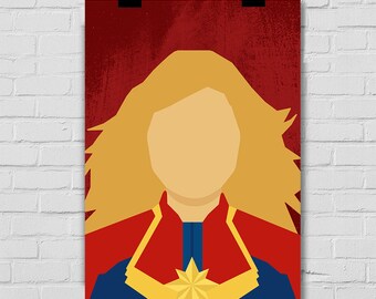Puede incluir: Un póster minimalista con una ilustración estilizada de Captain Marvel, una superheroína del Universo Cinematográfico Marvel. El póster tiene un fondo rojo con textura grunge y presenta una estrella amarilla en el pecho de Captain Marvel.