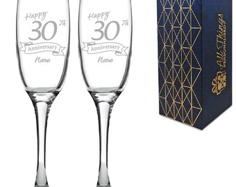 May include: Two clear glass champagne flutes with a silver inscription that reads "Happy 30th Anniversary Name". The flutes are in a blue and gold gift box with the words "All Things Personalised" on the side.