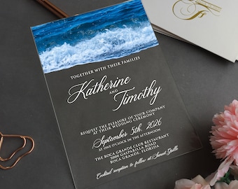 Könnte beinhalten: Hochzeitseinladung mit dunkelgrauem Hintergrund und einem Foto von Meereswellen oben. Die Namen "Katherine" und "Timothy" sind in eleganter Schrift geschrieben. Details beinhalten Datum, Uhrzeit und Ort der Zeremonie.