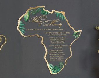May include: A wedding invitation in the shape of the African continent, with a gold border and tropical leaf accents. The invitation includes the names "Wilson & Mandy" and event details for October 16, 2022, at Terrace on the Park in Queens, NY.
